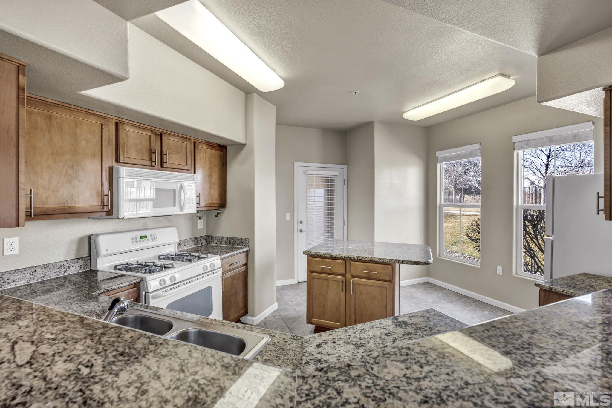 1325 South Meadows Parkway, Unit 412 Reno, NV 89521 - Photo 11 of 39 a kitchen with stainless steel appliances granite countertop a stove sink and cabinets