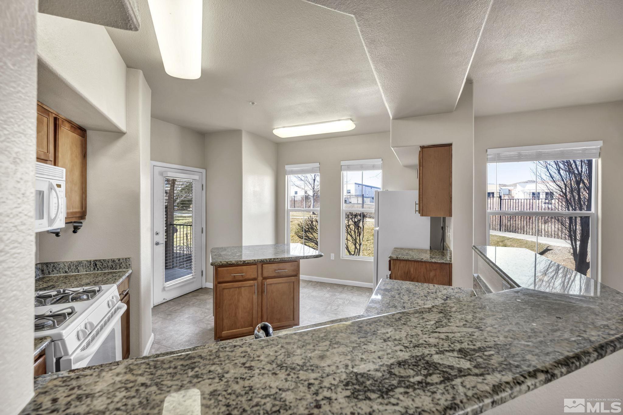 1325 South Meadows Parkway, Unit 412 Reno, NV 89521 - Photo 12 of 39 a view of a living room and kitchen with furniture