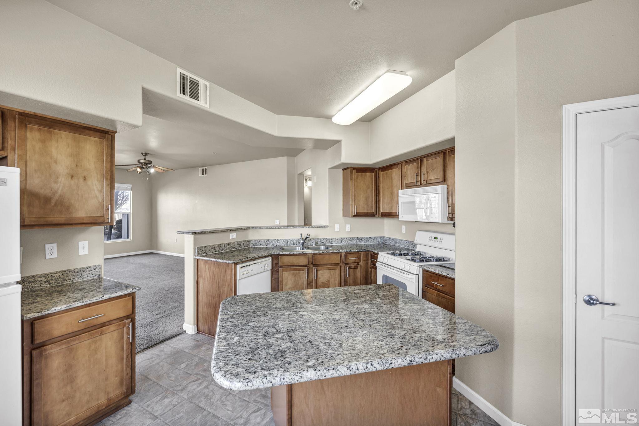 1325 South Meadows Parkway, Unit 412 Reno, NV 89521 - Photo 13 of 39 a kitchen with stainless steel appliances granite countertop a sink stove and refrigerator
