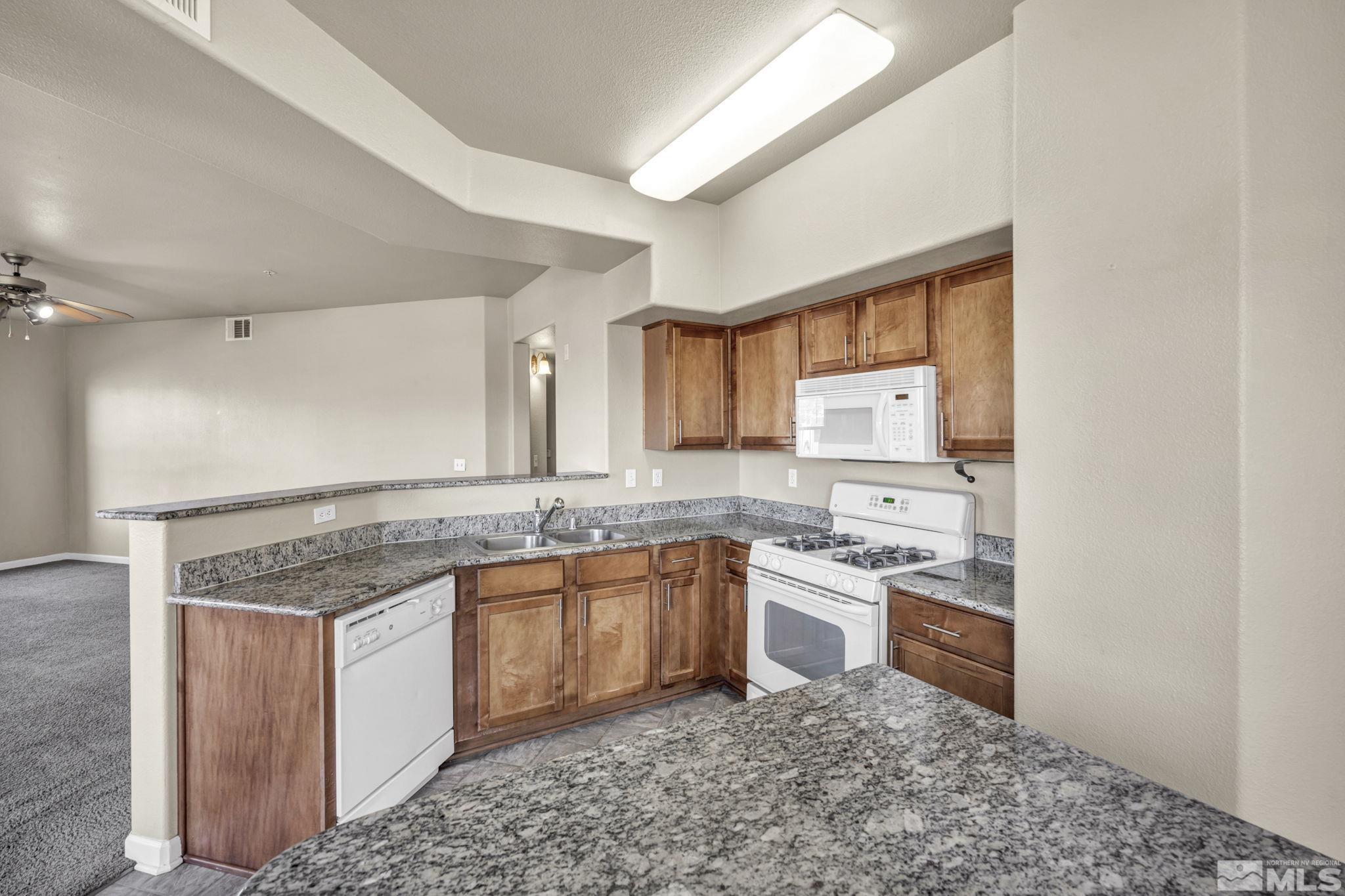 1325 South Meadows Parkway, Unit 412 Reno, NV 89521 - Photo 14 of 39 a kitchen with a sink stove and cabinets