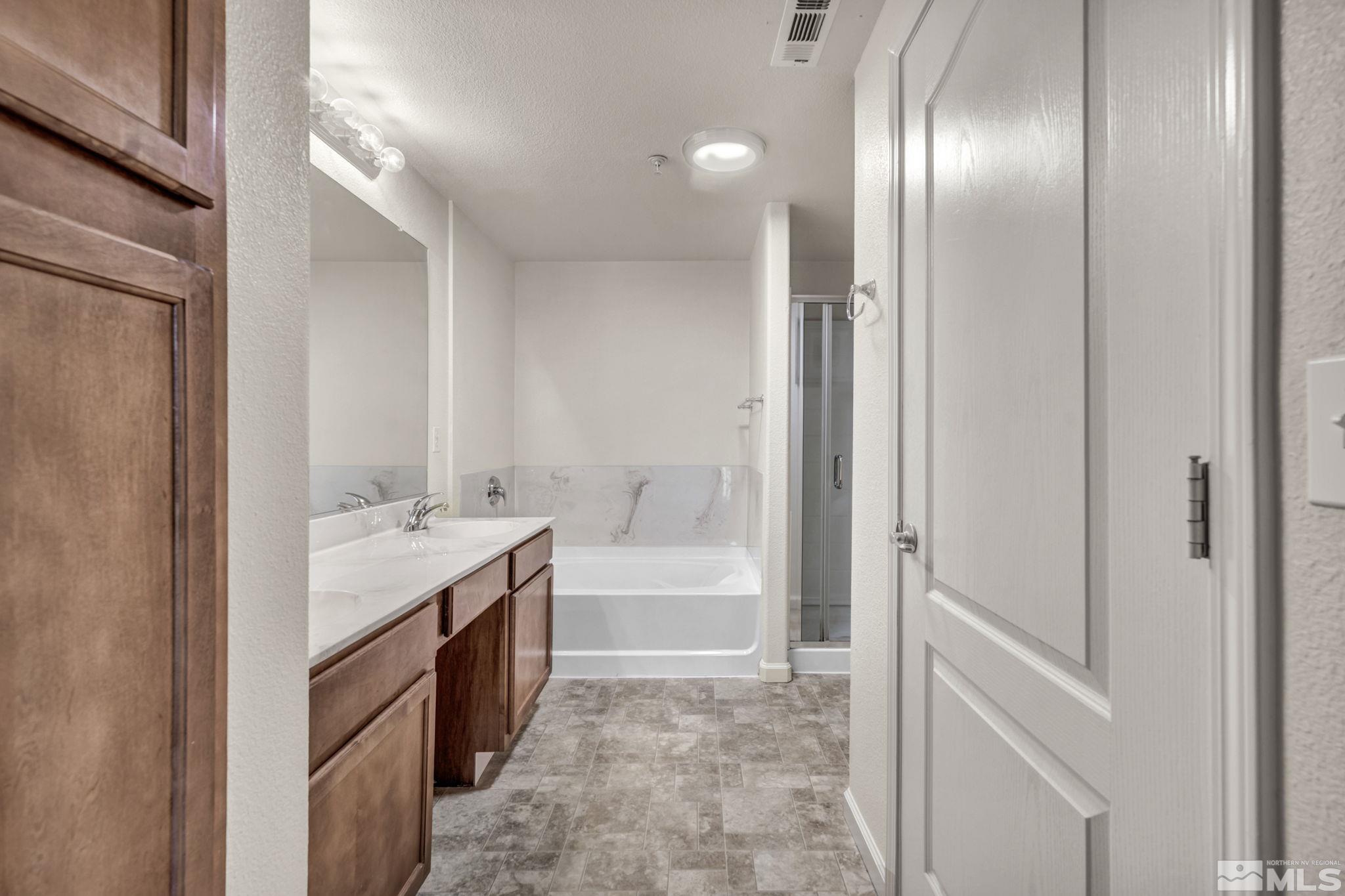 1325 South Meadows Parkway, Unit 412 Reno, NV 89521 - Photo 20 of 39 a bathroom with a tub sink and mirror