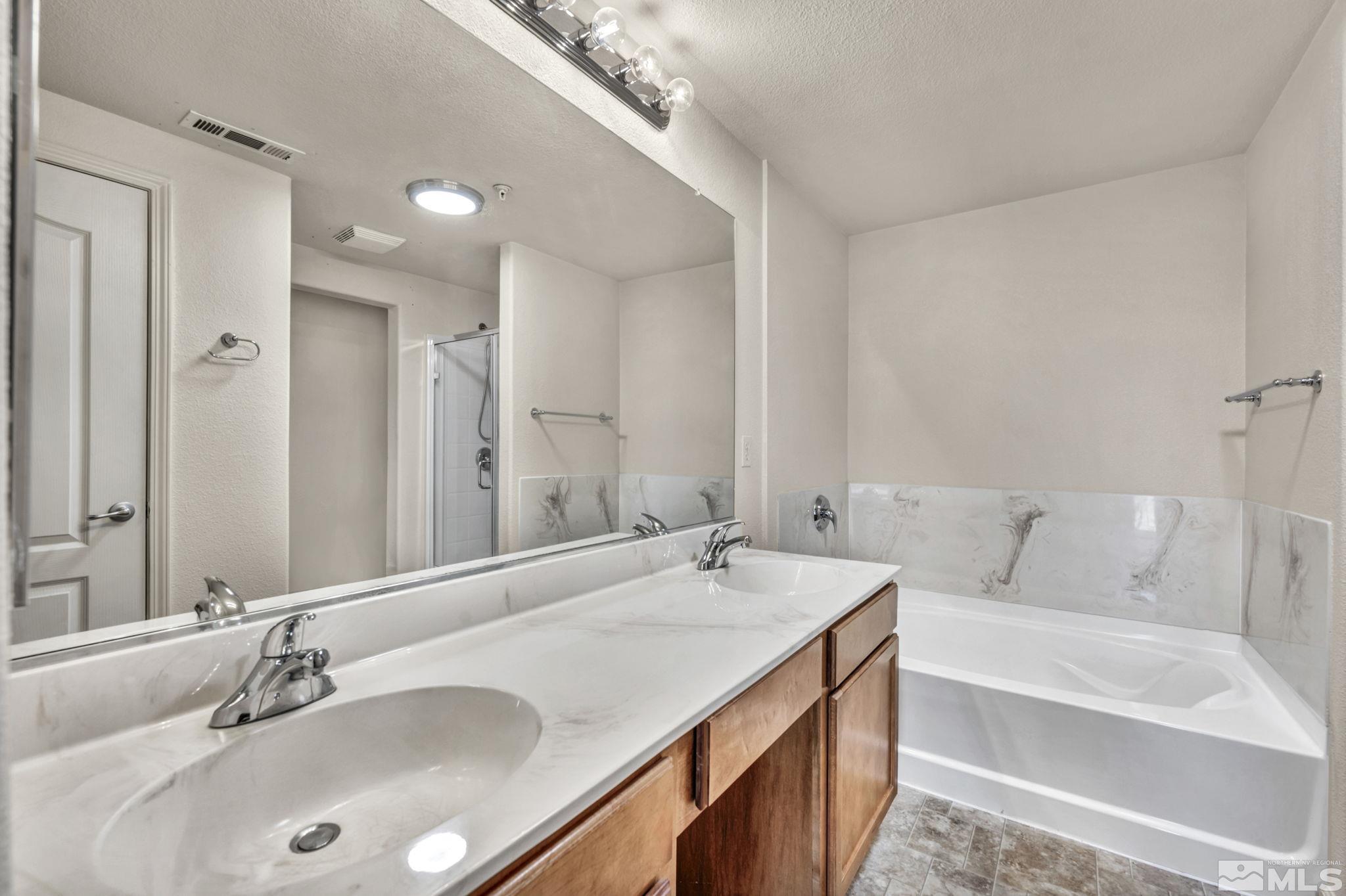 1325 South Meadows Parkway, Unit 412 Reno, NV 89521 - Photo 25 of 39 a bathroom with a tub a sink and a mirror