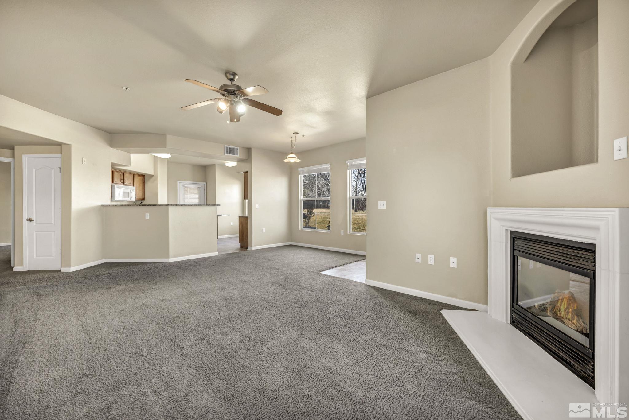 1325 South Meadows Parkway, Unit 412 Reno, NV 89521 - Photo 5 of 39 a view of a livingroom with a fireplace a ceiling fan and windows