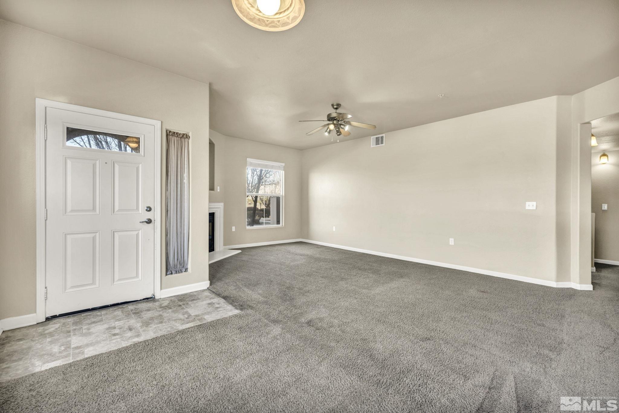 1325 South Meadows Parkway, Unit 412 Reno, NV 89521 - Photo 8 of 39 an empty room with windows and chandelier fan