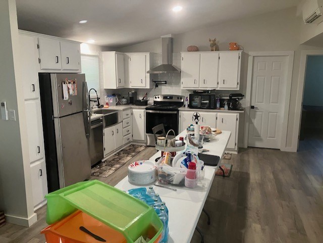 425 Post Hill Street Mason, TX 76856 - Photo 7 of 18 a kitchen with a refrigerator a stove top oven a sink dishwasher and white cabinets with wooden floor