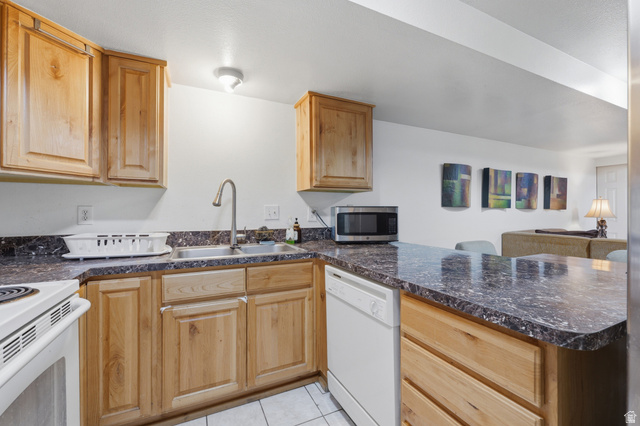 1700 Hickory Lane Provo, UT 84604 - Photo 14 of 20 Kitchen featuring wood cabinetry, white appliances, a stainless steel sink with a gooseneck faucet, and dark speckled countertops