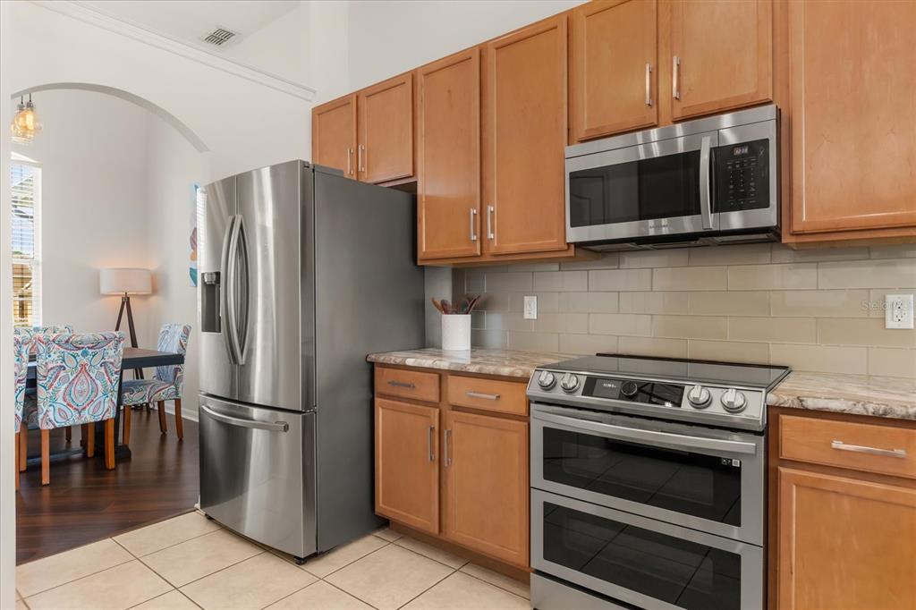 2309 Wolf Ridge Lane Mount Dora, FL 32757 - Photo 14 of 36 a kitchen with granite countertop a refrigerator stove and microwave
