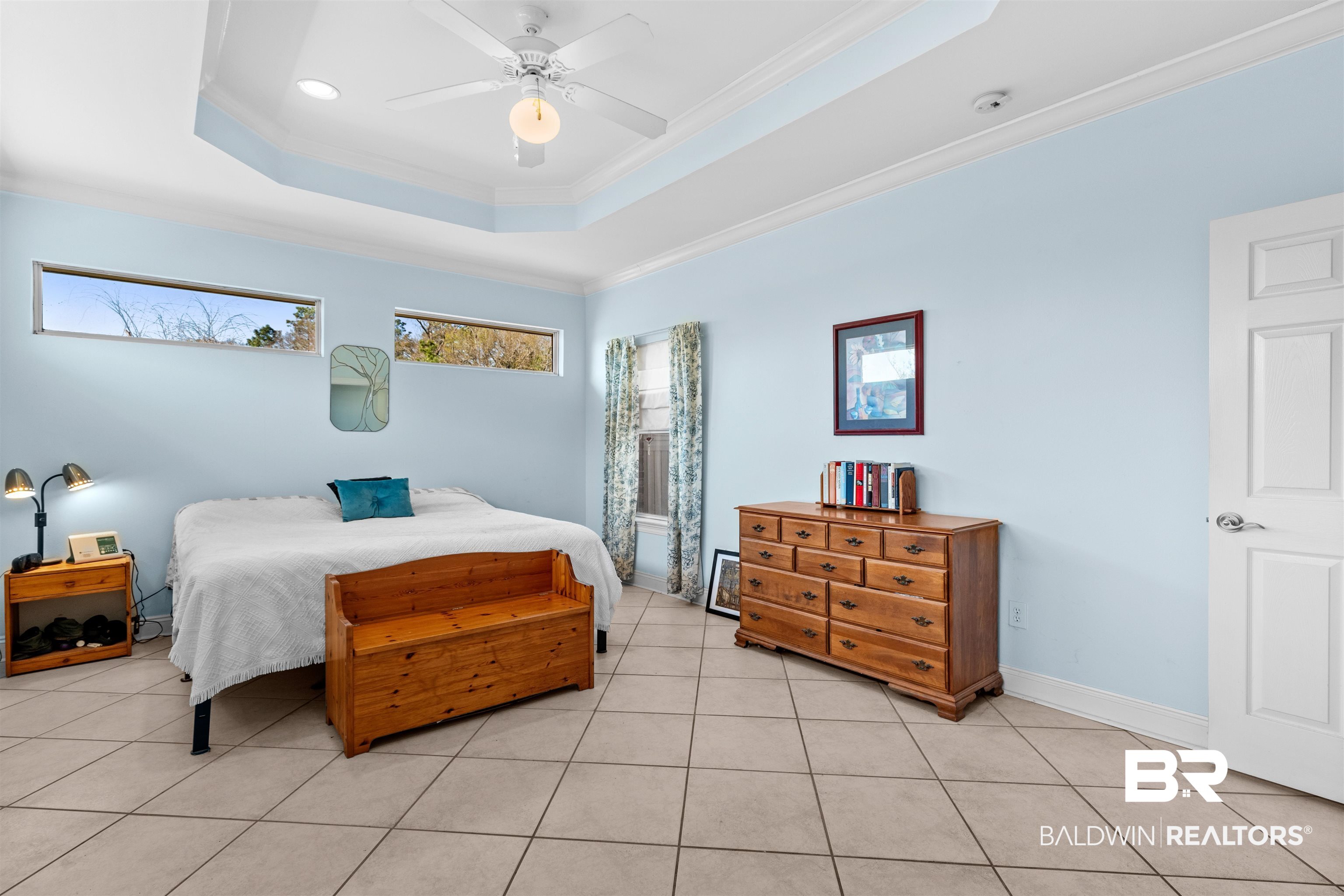 237 Hemingway Loop Foley, AL 36535 - Photo 14 of 49 Bedroom featuring light tile patterned floors, baseboards, a tray ceiling, ceiling fan, and ornamental molding
