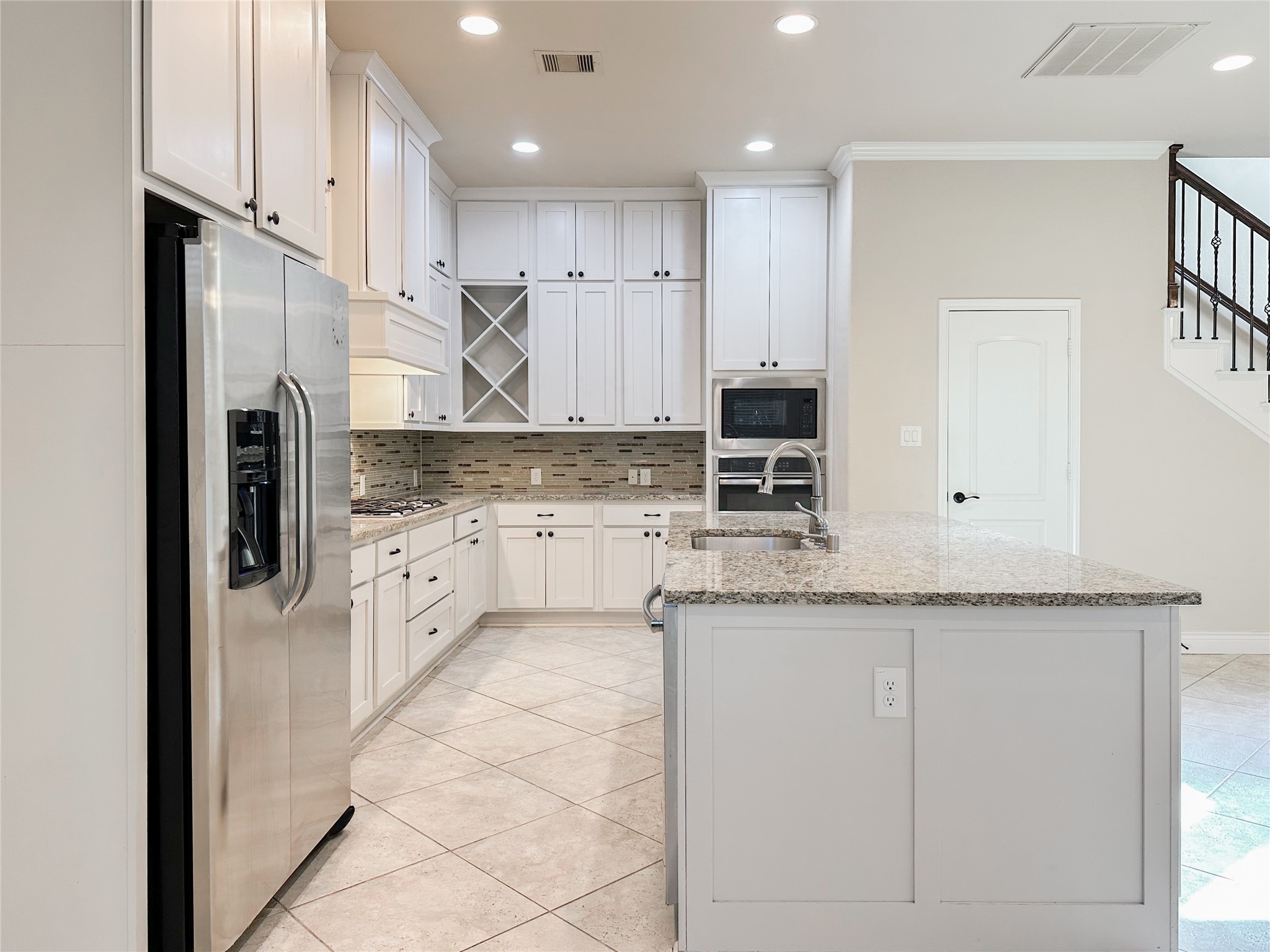 a large kitchen with granite countertop a white stove top oven and refrigerator