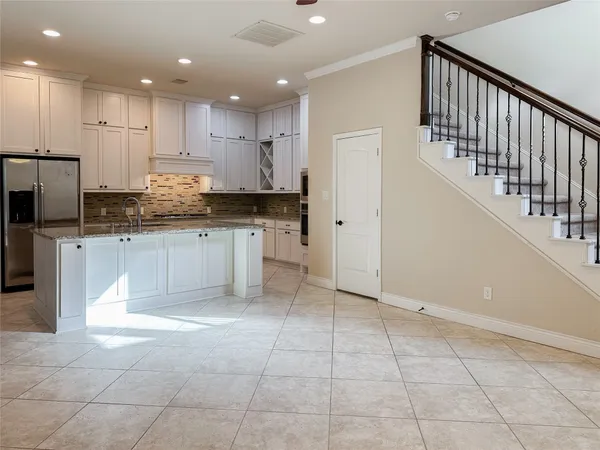 a large kitchen with stainless steel appliances granite countertop a large counter top and a stove top oven
