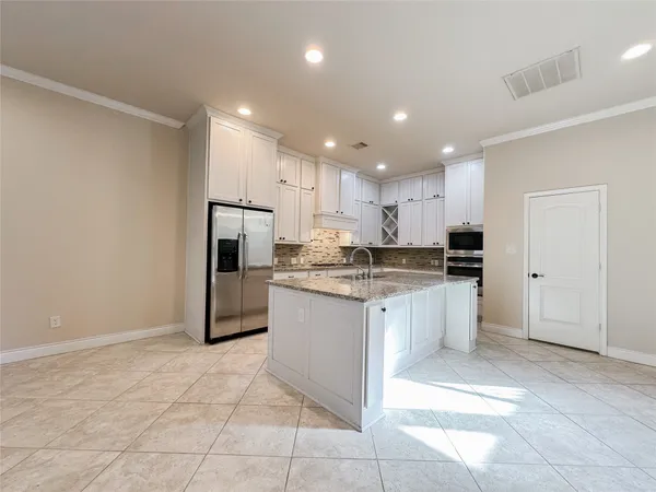 a kitchen with stainless steel appliances granite countertop a refrigerator and a sink