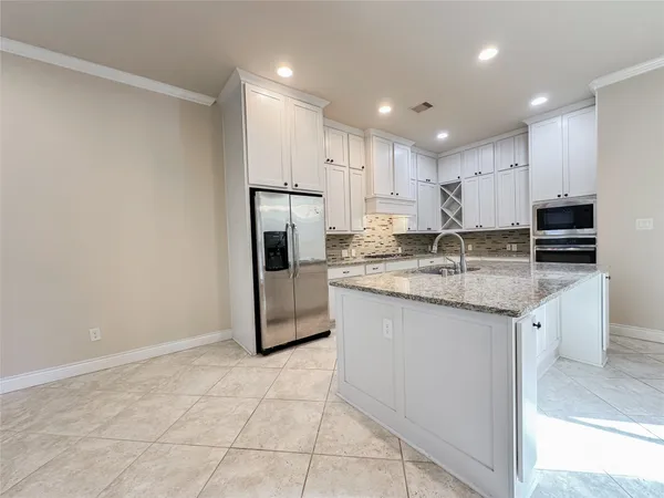 a kitchen with kitchen island granite countertop appliances cabinets and a sink