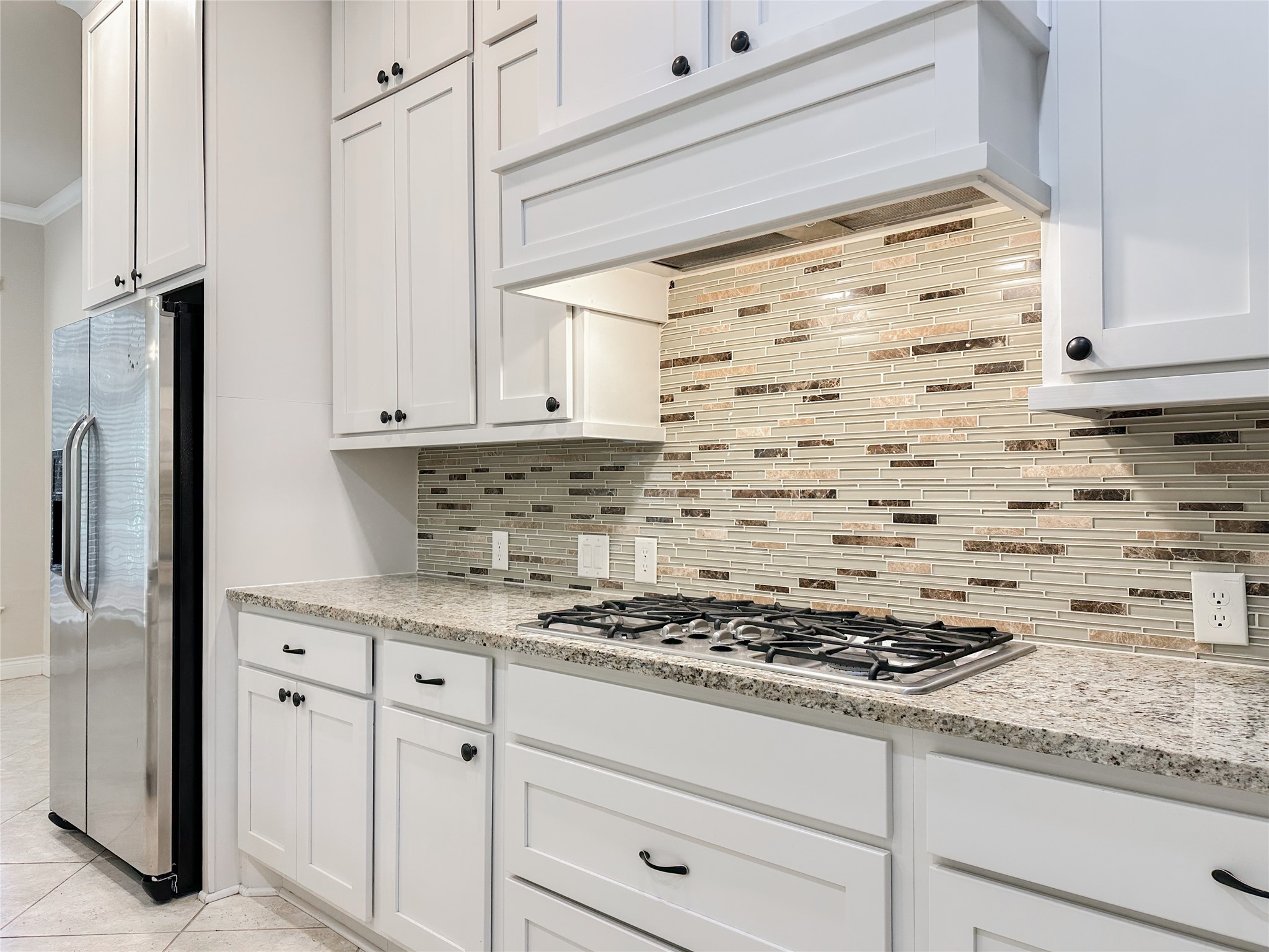 23 Jonquil Place Tomball, TX 77375 - Photo 21 of 50 a kitchen with granite countertop cabinets and a stove