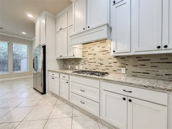a kitchen with granite countertop white cabinets and stainless steel appliances