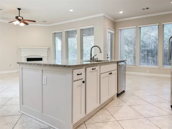 a kitchen with white cabinets and chandelier