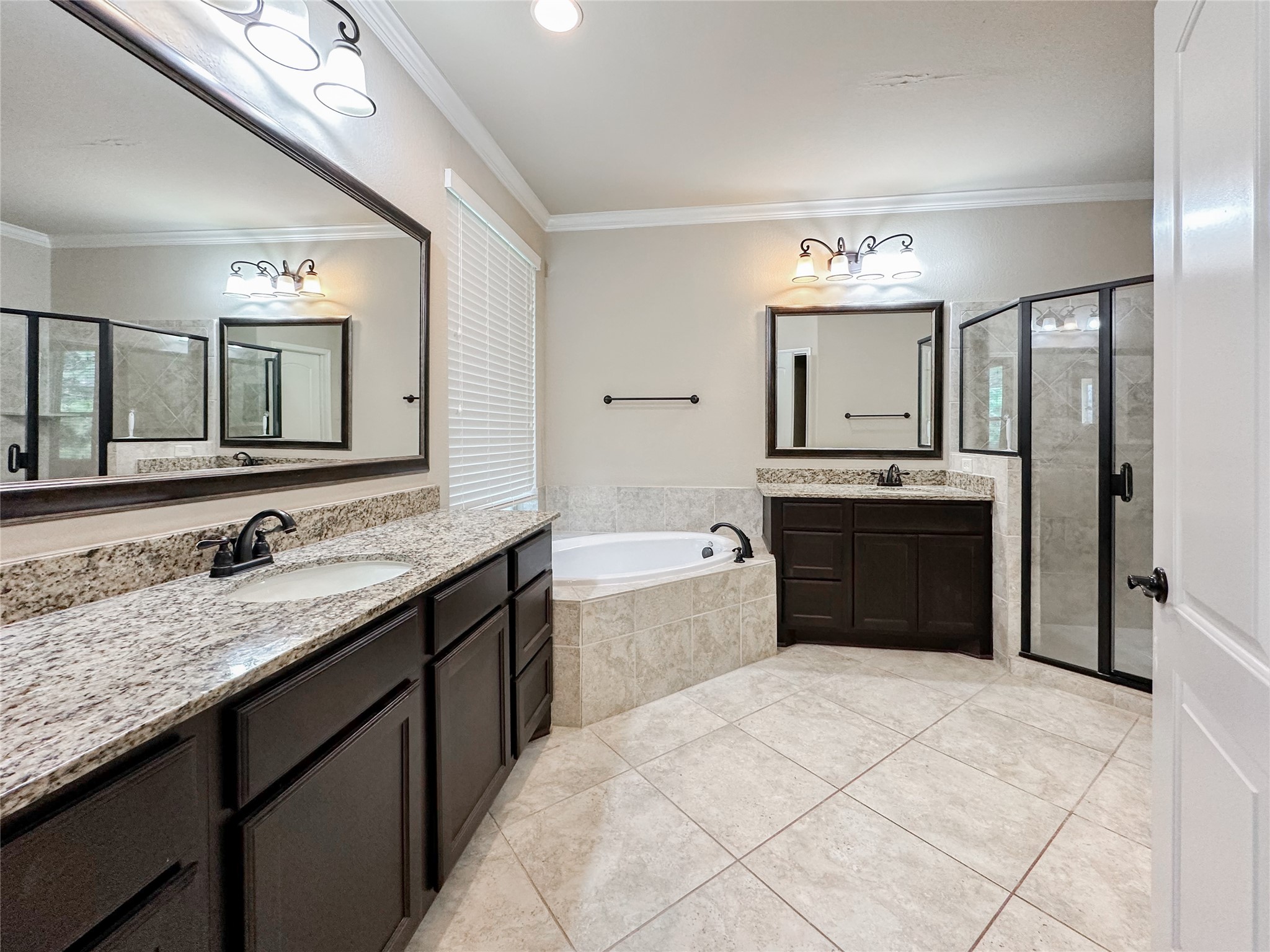 23 Jonquil Place Tomball, TX 77375 - Photo 29 of 50 a spacious bathroom with a granite countertop sink and a mirror