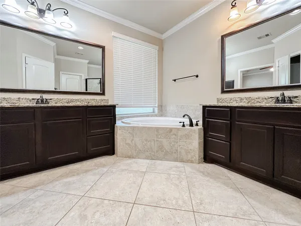 a spacious bathroom with a granite countertop sink a mirror and a bathtub