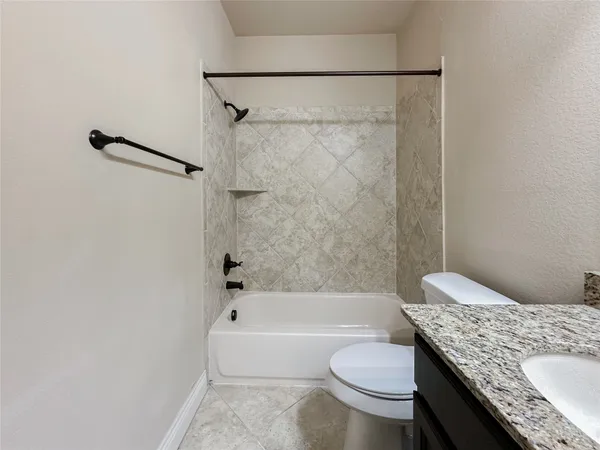 a bathroom with a granite countertop toilet sink and bathtub
