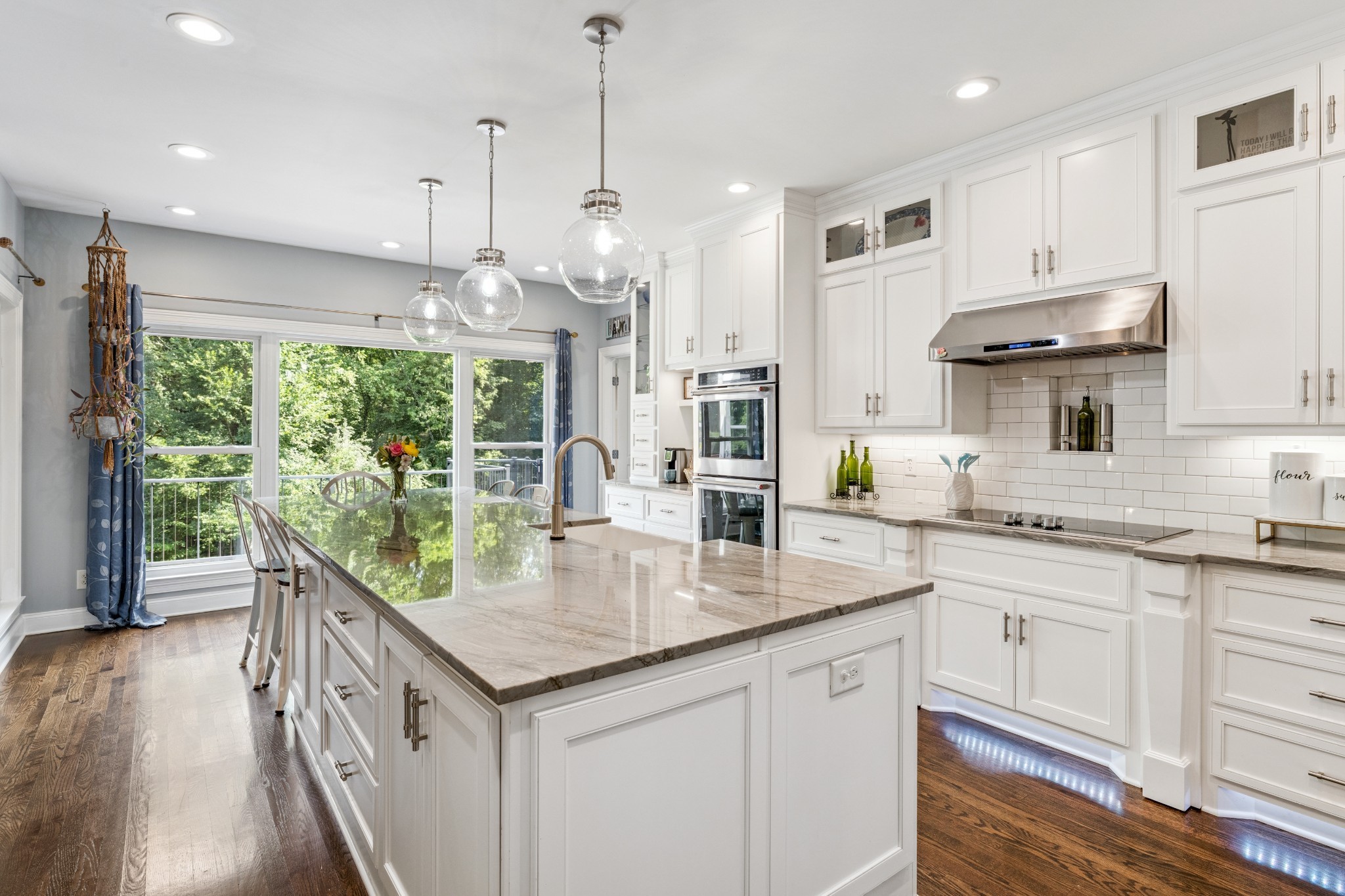 a kitchen with stainless steel appliances granite countertop a sink a stove and a wooden floors