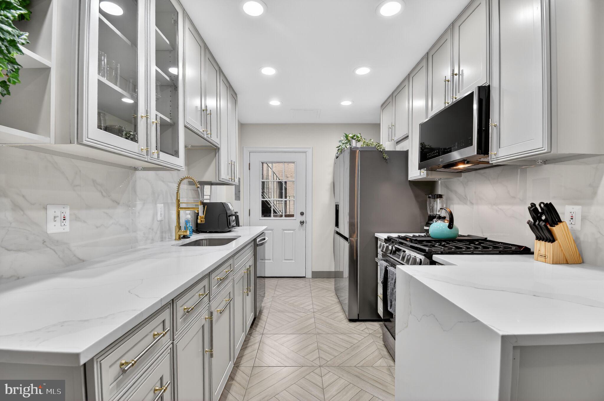 1919 19th Street Northwest, Unit 302 Washington, DC 20009 - Photo 5 of 16 a kitchen with stainless steel appliances granite countertop a sink stove and refrigerator
