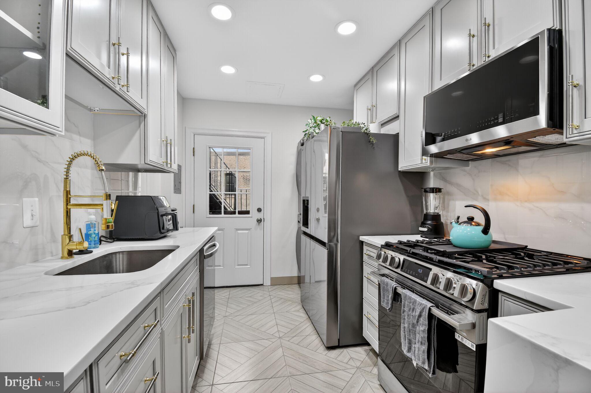 1919 19th Street Northwest, Unit 302 Washington, DC 20009 - Photo 6 of 16 a kitchen with stainless steel appliances granite countertop a sink stove and refrigerator