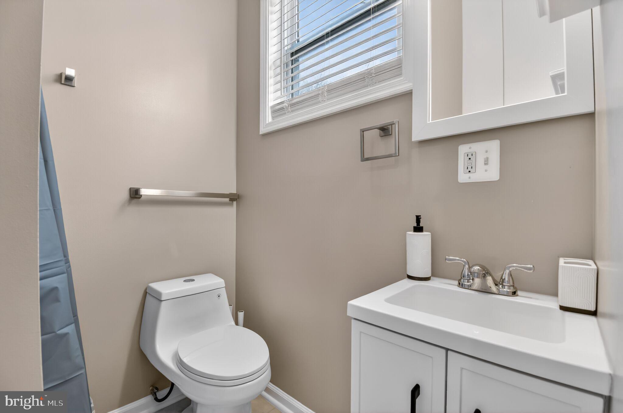 1919 19th Street Northwest, Unit 302 Washington, DC 20009 - Photo 7 of 16 a bathroom with a sink a toilet and a window