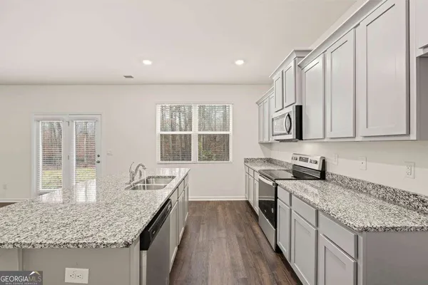 a kitchen with stainless steel appliances granite countertop a sink stove and cabinets