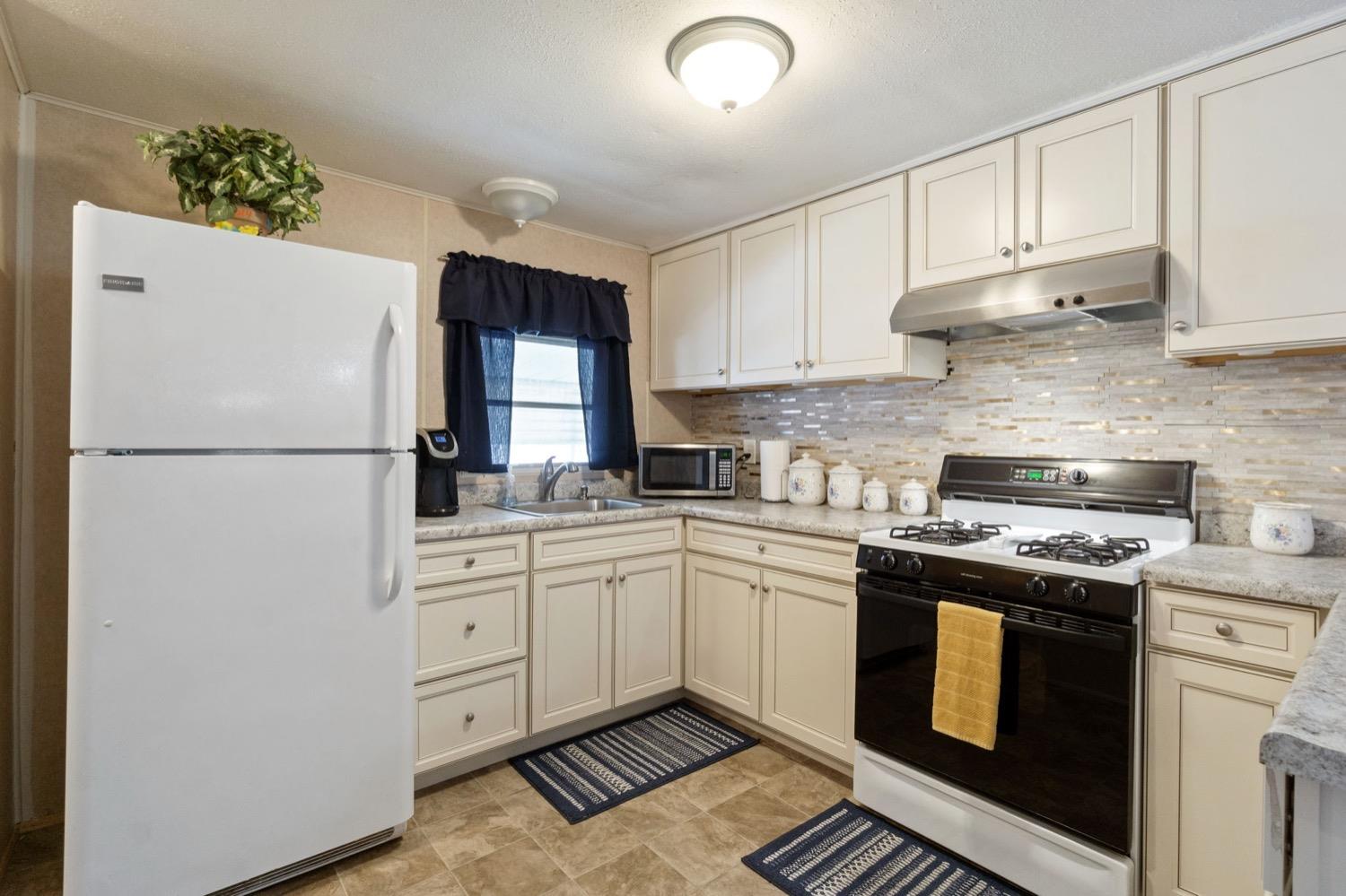 1500 Villa Avenue Clovis, CA 93612 - Photo 11 of 28 a kitchen with a refrigerator sink and cabinets
