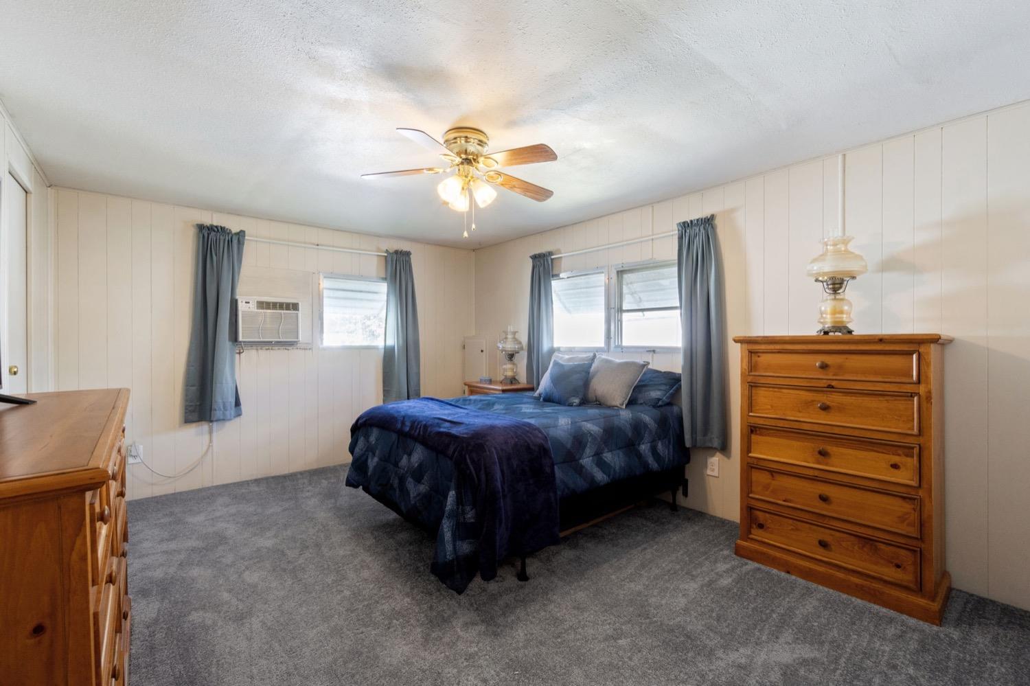 1500 Villa Avenue Clovis, CA 93612 - Photo 19 of 28 a spacious bedroom with a bed and a chandelier