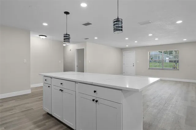 a view of a kitchen with a sink and chandelier