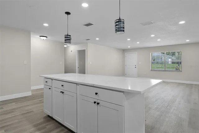 a view of a kitchen with a sink and chandelier