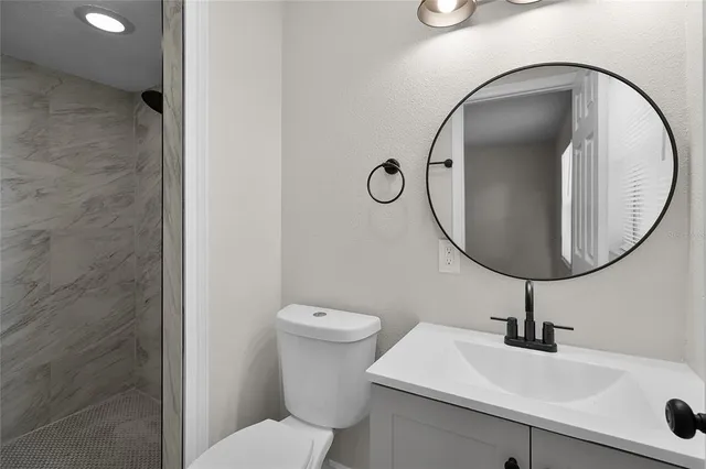 a bathroom with a sink a toilet and a mirror
