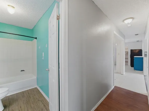 an empty room with chandelier fan and windows