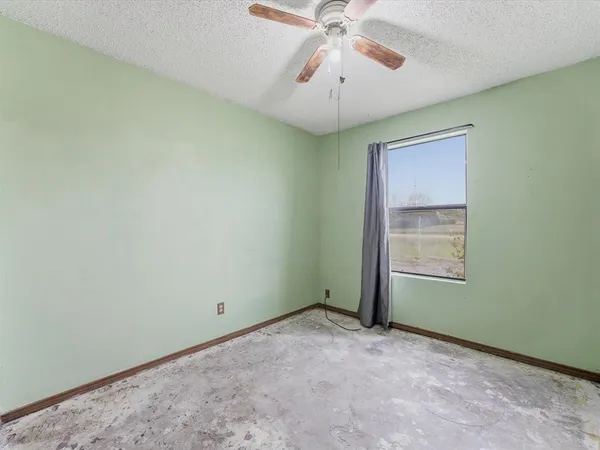 an empty room with closet and a ceiling fan