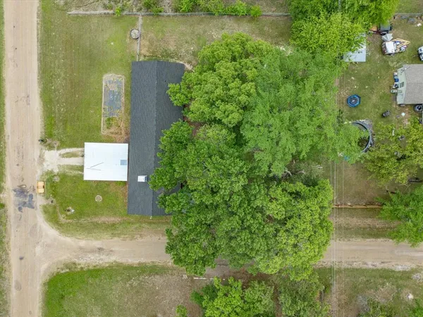 an aerial view of residential houses with outdoor space and trees
