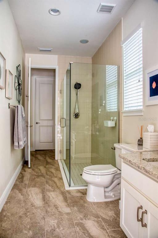 11539 Tapestry Lane Venice, FL 34293 - Photo 12 of 21 a bathroom with a granite countertop toilet a sink and a shower