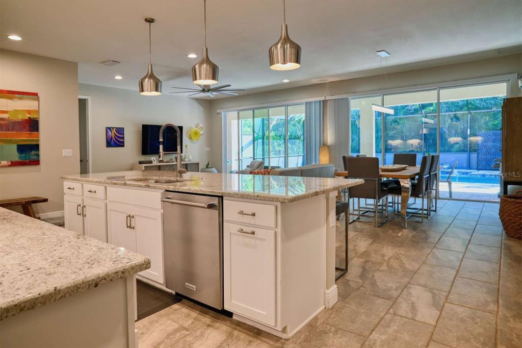 11539 Tapestry Lane Venice, FL 34293 - Photo 17 of 21 a kitchen with kitchen island granite countertop a stove center island a stove and a view of living room