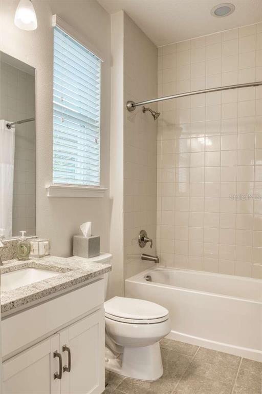 11539 Tapestry Lane Venice, FL 34293 - Photo 9 of 21 a bathroom with a granite countertop toilet a sink and a bathtub