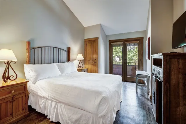 a bedroom with a bed a flat screen tv and dresser