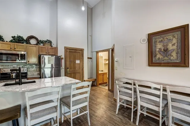 a view of a kitchen filled with furniture and wooden floor