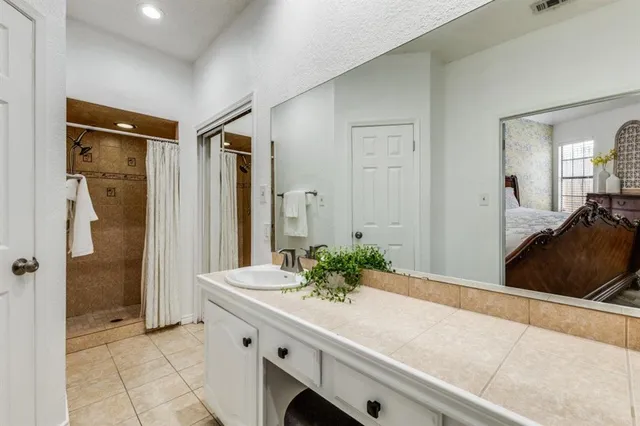a spacious bathroom with a granite countertop sink and a mirror