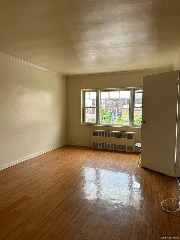 47-05 Newtown Road Queens, NY 11103 - Photo 9 of 21 a view of a room with wooden floor and windows