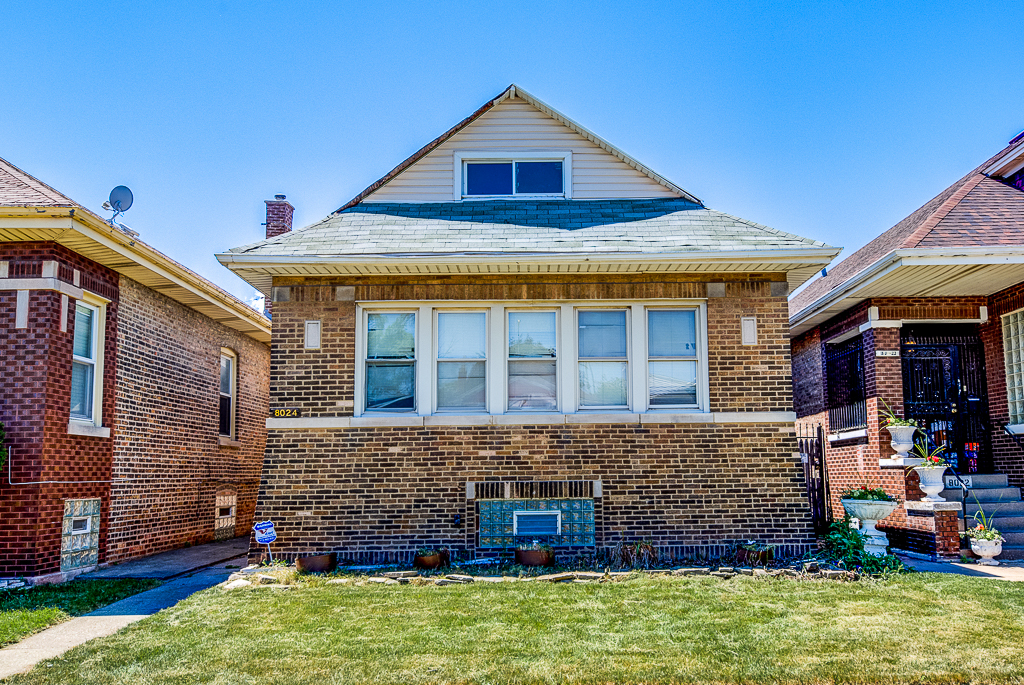 8024 South Perry Avenue Chicago, IL 60620 - Photo 1 of 37 a front view of a house with garden