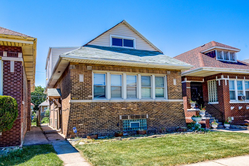 8024 South Perry Avenue Chicago, IL 60620 - Photo 2 of 37 a front view of a house with garden