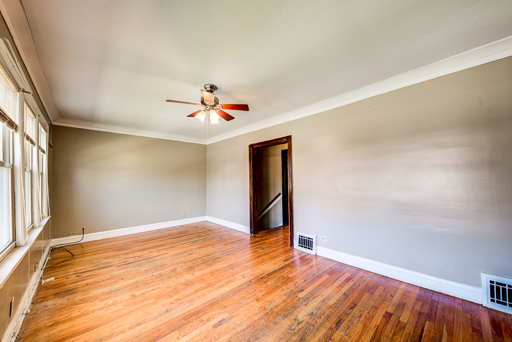 8024 South Perry Avenue Chicago, IL 60620 - Photo 18 of 37 a view of an empty room with wooden floor and a window