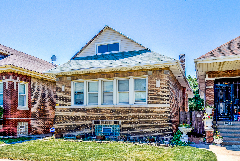 8024 South Perry Avenue Chicago, IL 60620 - Photo 3 of 37 a front view of a house with a yard