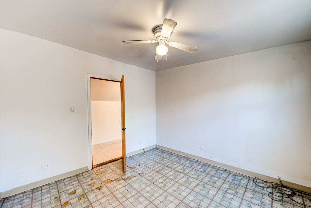 8024 South Perry Avenue Chicago, IL 60620 - Photo 23 of 37 an empty room with a chandelier fan and windows