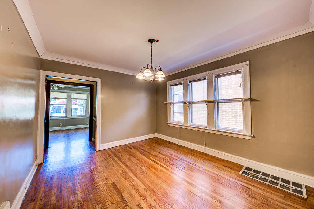 8024 South Perry Avenue Chicago, IL 60620 - Photo 6 of 37 a view of an empty room with window and wooden floor