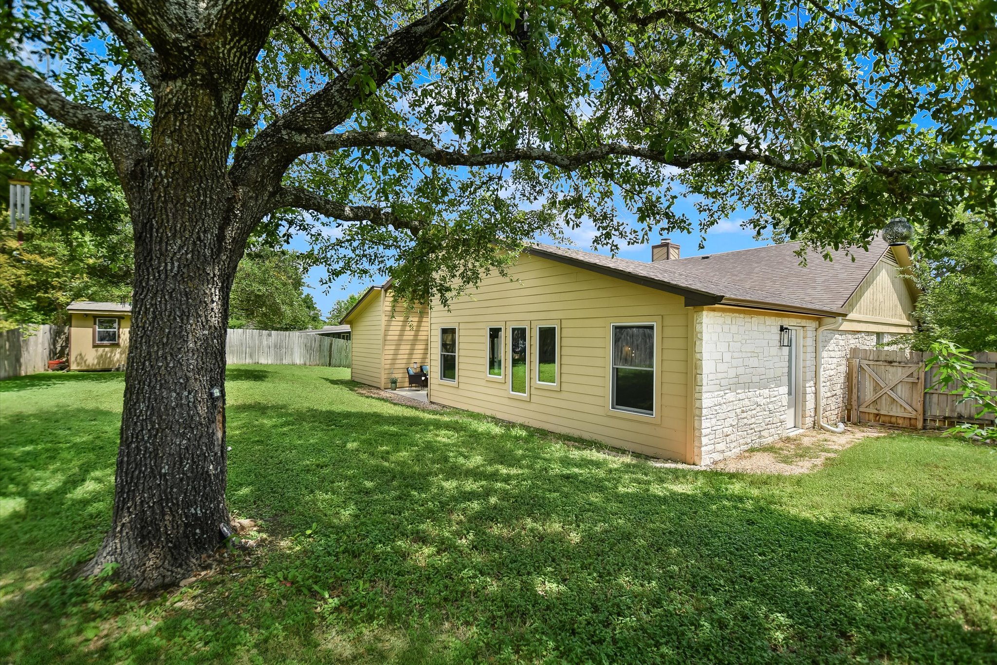 1002 West Noton Street Pflugerville, TX 78660 - Photo 5 of 32 The large backyard has a large shade tree and a shed.