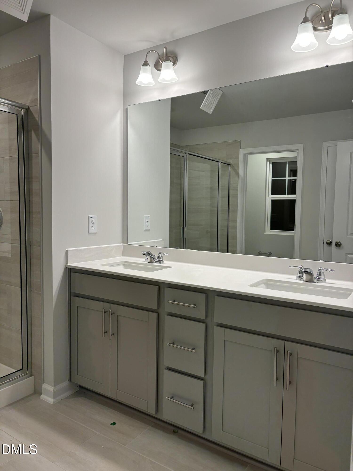 2011 Rabbit Hop Trail Apex, NC 27502 - Photo 15 of 27 a bathroom with double sink and a mirror